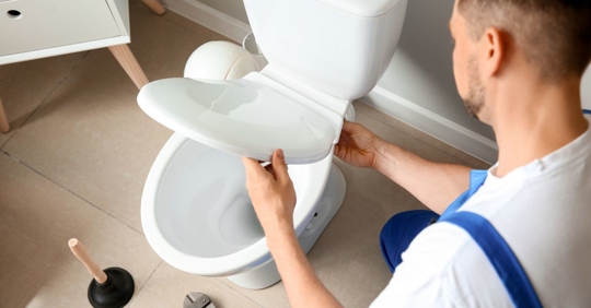 plumber installing toilet